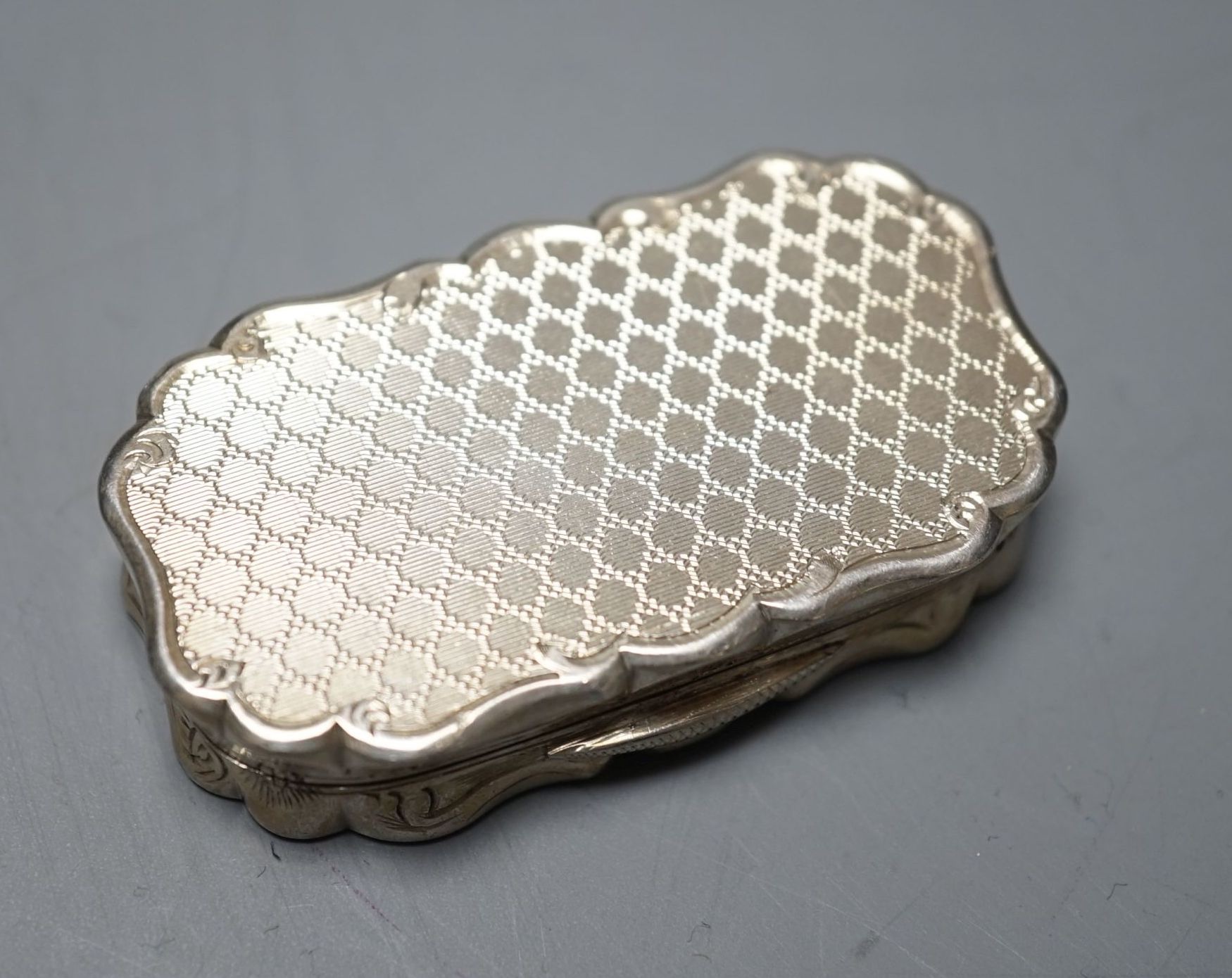 A Victorian engine turned silver shaped oval vinaigrette, by George Unite, Birmingham, 1868, 54mm.